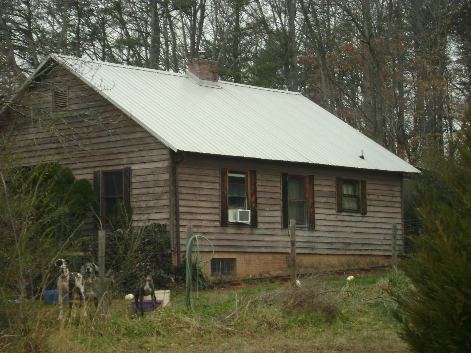 White metal roof on an old wood sided farmhouse, from a Metal Roof Installation job in Youngsville